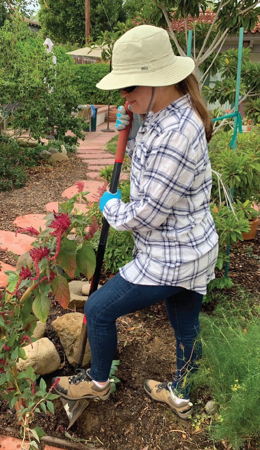 Close-toed shoes with a good sole, gloves and a hat protect this gardener from the sun and pressure-point injuries. 